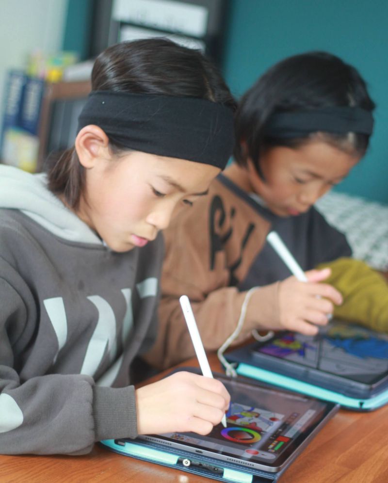 写真：タブレットで子供がイラスをと書いている